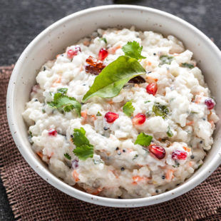 Riz au lait caillé de style sud-indien dans un bol blanc garni d'arilles de grenade