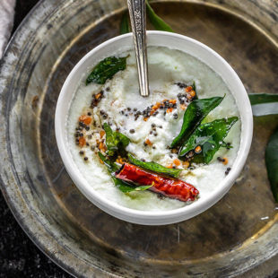 boule de coconut chutney tempéré avec des feuilles de curry, des graines de moutarde, piments rouges séchés et servi à la cuillère