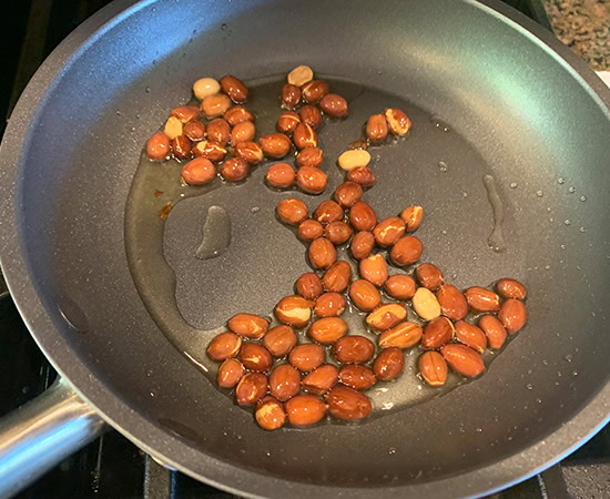 peanuts being cooked in a small pan