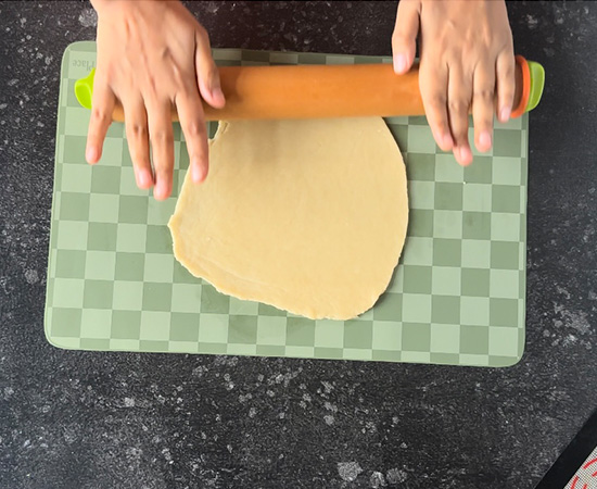 dough being rolled using a rolling pin