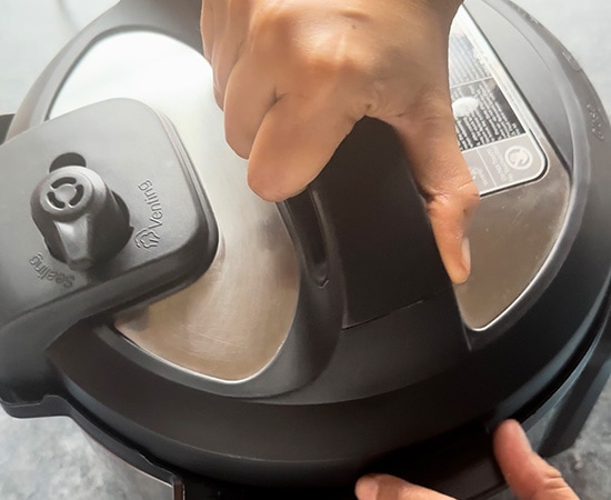hand closing the lid of the instant pot