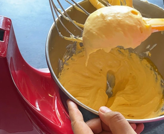 a spatula holding mango mascarpone mixture to show it's texture