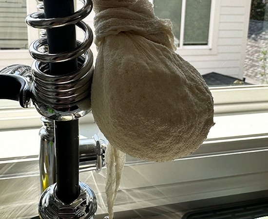 chena tied in a muslin cloth hanging from a tap