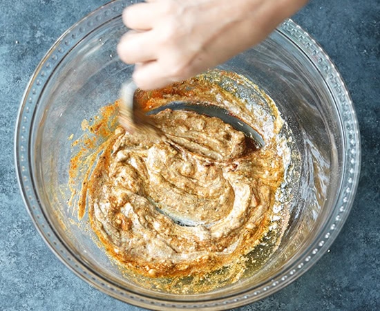 hand whisking marinade in a bowl