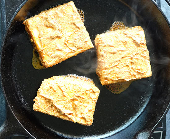 slabs of marinated paneer in a pan