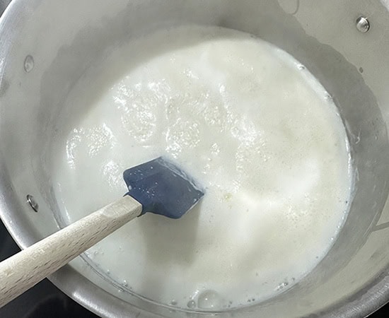 a spatula stirring milk in a pot