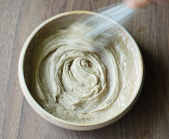 a whisk mixing tahini sauce