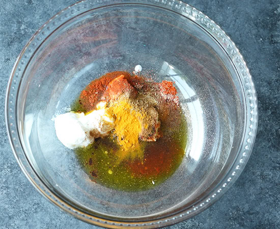 spices with oil, yogurt in a large bowl