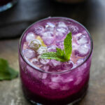 jamun drink topped with round ice cubes and garnished with mint