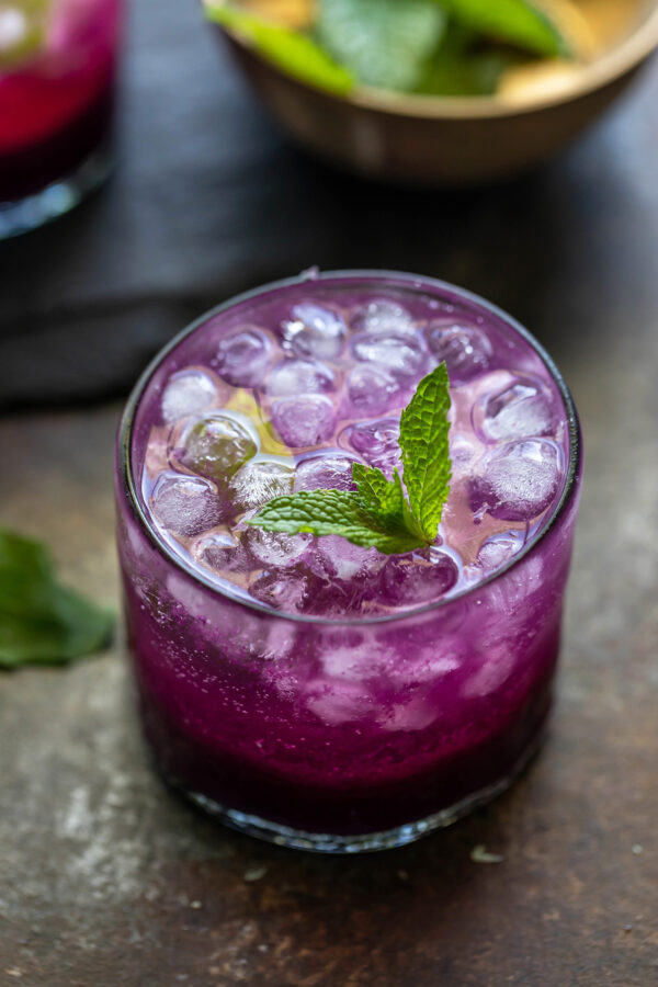 jamun drink topped with round ice cubes and garnished with mint