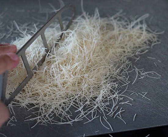 a knife cutting the kataifi pastry 