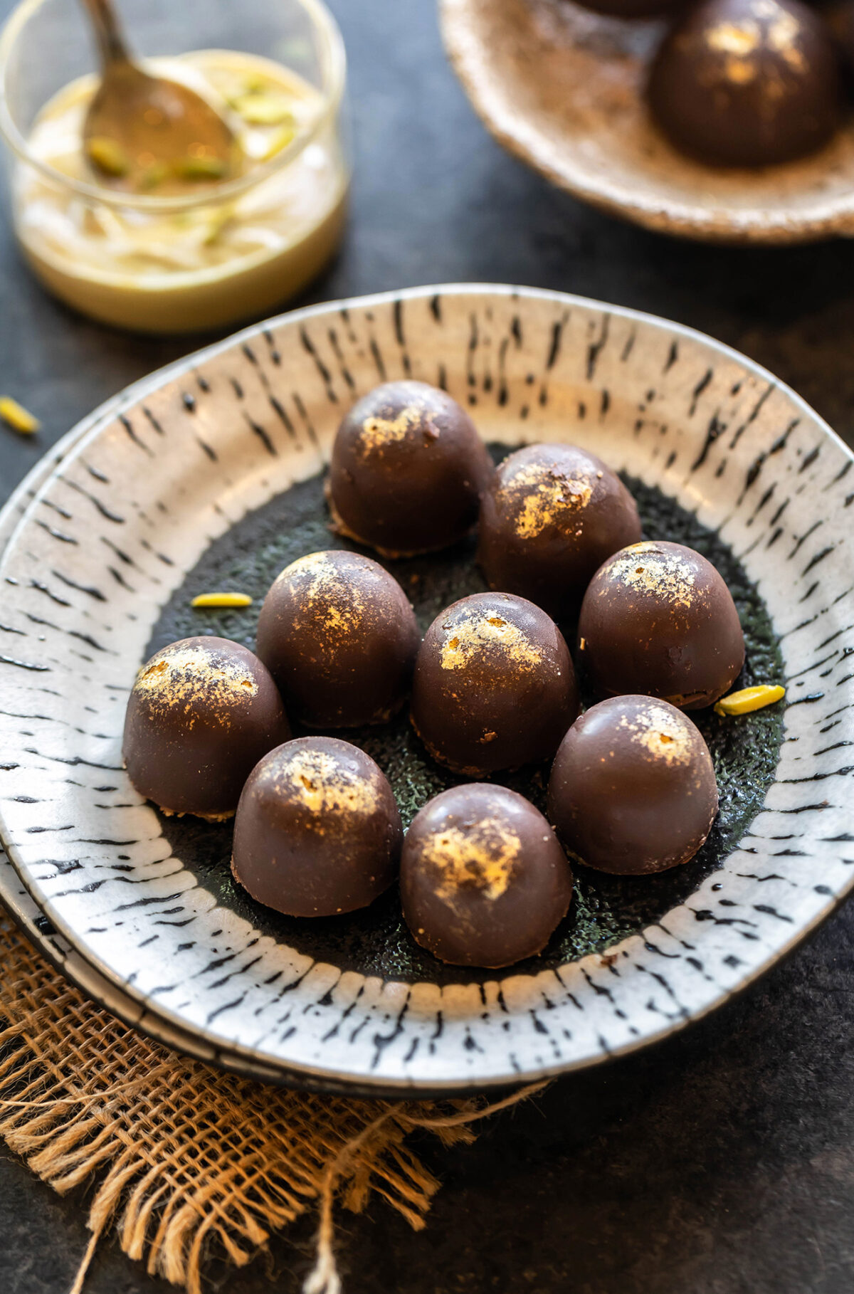 9 chocolate truffles dusted with edible gold arranged in a plate