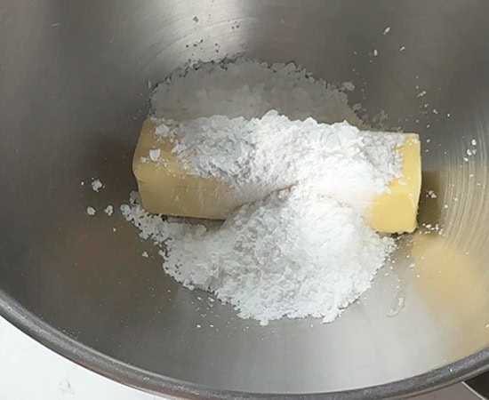 stick of butter with powdered sugar in a bowl