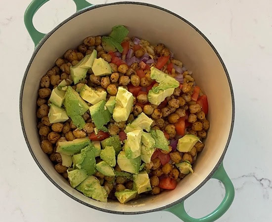 a large pot with chickpeas, cubed avocado, onions, tomatoes