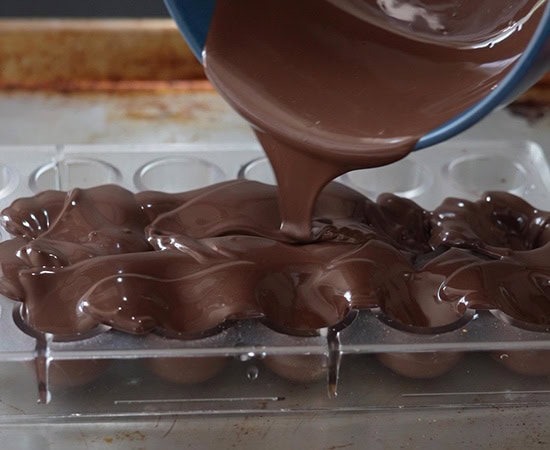 melted chocolate being poured over a mold