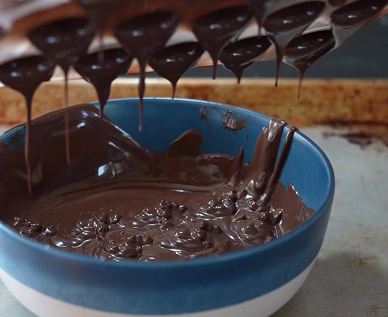 chocolate mold being inverted upside down to remove excess chocolate