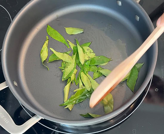 curry leaves being sauteed in a pan