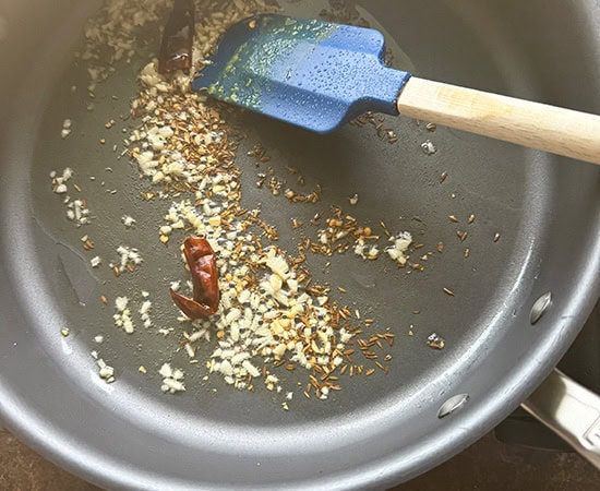 chopped garlic, red chilies added to oil in a pan