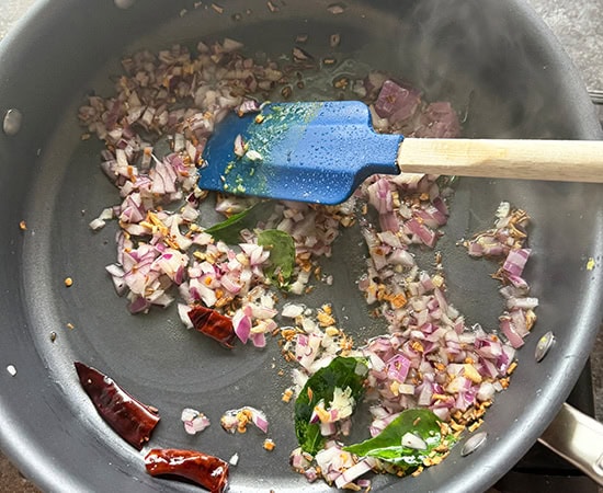 onion and curry leaves added to oil in a pan