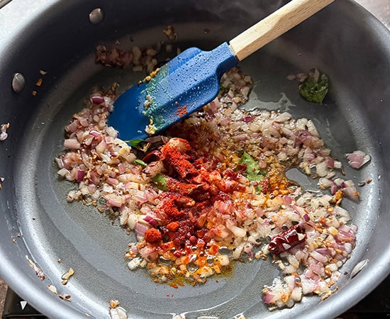 red chili powder added to tadka in a pan